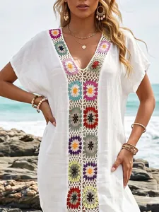 Detailweergave van kleurrijke handgehaakte bloemen op de witte strand-cover-up