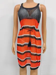 Close-up of orange and black striped knit beach cover-up with tassel belt detail