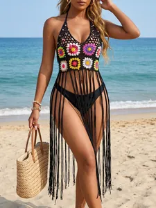 Bohemian hand-crocheted floral bikini cover-up with long fringe on a sunny beach