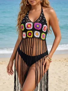 Close-up of black crochet beach cover-up with colorful granny square flowers and long fringes.