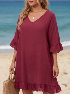 Detalle de vestido de playa granate con cuello en V y volantes en mangas