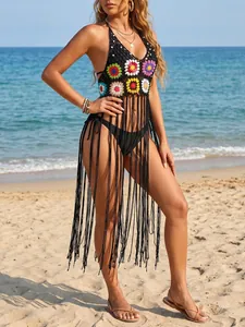 Detailed view of handmade crochet beach cover-up with long tassels and floral design