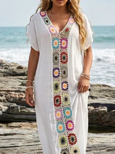 Elegant detail van een witte strandhoes met kleurrijk gehaakt bloemen-patchworkontwerp.