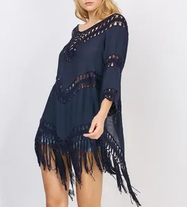 Detail of navy blue crochet beach cover-up with fringe and hollow-out lace design.