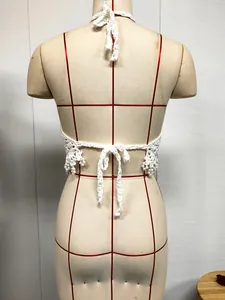 Vue arrière détaillée d'un haut dos nu au crochet blanc avec pampilles de perles et lacets