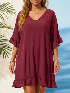 Detalle de un vestido de playa burdeos suelto con cuello en V y volantes en las mangas