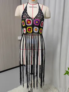 Detailed view of handmade crochet bikini cover-up with colorful granny squares and long fringe.