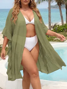 Olive green plus size ruffle sleeve cardigan beach cover-up shown in outdoor resort setting