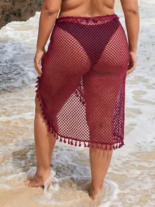 Vista detallada de falda playera de malla granate con flecos en la playa