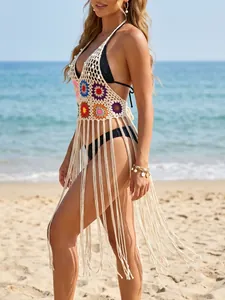 Detail view of crochet beach cover-up featuring colorful floral knit and long fringe.