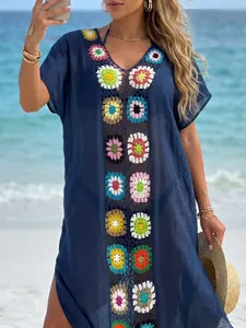 Detailweergave van donkerblauwe strandjurk met kleurrijke gehaakte bloemenmotieven