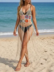 Detailed view of hand-crocheted floral bikini cover-up with long tassels on beach