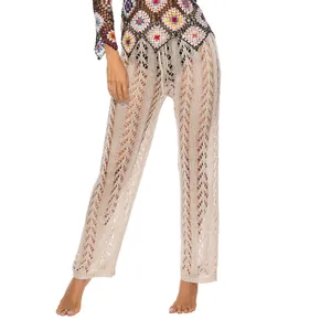 Vista dettagliata dei pantaloni da spiaggia in crochet beige con motivo traforato.