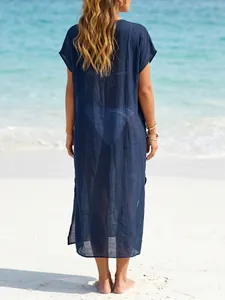 Achteraanzicht van een lange marineblauwe transparante strandjurk op wit zandstrand