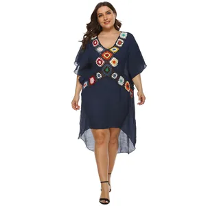 Detail view of a bohemian plus size navy beach cover-up with vibrant crochet flower patterns