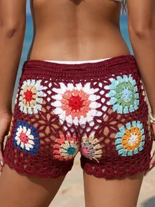 Close-up detail of handmade granny square crochet patchwork on bohemian beach hot pants.