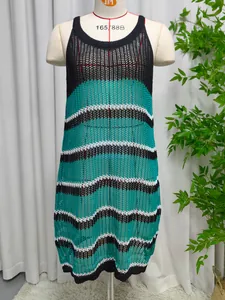Close-up view of a hollow knit beach dress featuring teal and black striped patterns