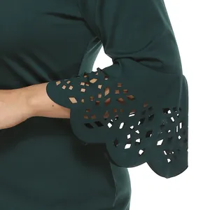 Dettaglio della manica a campana verde scuro con motivi a rombi tagliati al laser e bordo smerlato.