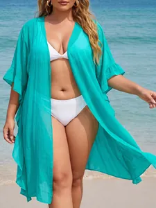 Close-up detail of a plus-size teal ruffled beach cover-up over a white bikini set