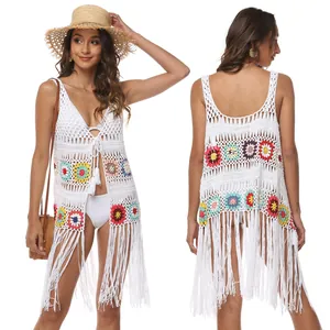 Detailed view of hand-crocheted white beach cover-up with colorful floral motifs