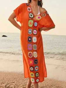 Stijlvolle oranje strand-cover-up met levendige kleurrijke gehaakte bloemendetails