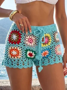 Close-up of handmade crochet grandmother square patchwork beach shorts with drawstring detail