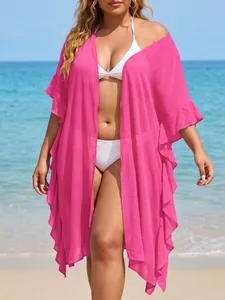 Plus size bright pink ruffled beach cover-up shown in a sunny seaside vacation setting.