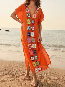 Boho stijl oranje strandcover-up met kleurrijke gehaakte bloemen patchwork details.