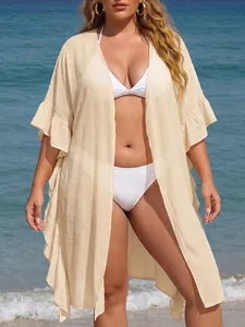 Beige ruffle sleeve plus size beach cover up cardigan over white bikini at seaside