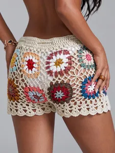 Detail view of handmade crochet granny square beach shorts with vibrant colorful floral patterns
