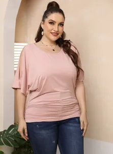 Detail of plus-size pink cold-shoulder top with batwing sleeves and ruched hem.
