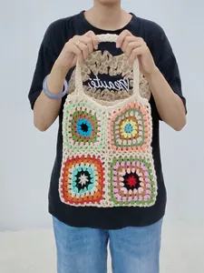 Handmade crochet granny square tote bag featuring vibrant colorful patchwork patterns.