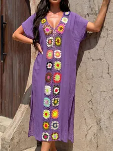 Detailweergave van de kleurrijke gehaakte bloemen op deze paarse bohemian strand cover-up.