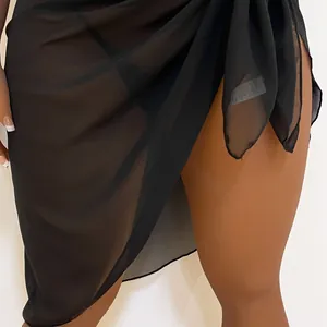 Macro detail of a sheer black chiffon beach sarong showing fabric texture and tie-waist.