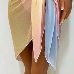 Close-up of gradient tie-dye beach sarong skirt with irregular hem and sheer fabric texture.