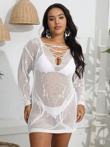 Detailed shot of a white crocheted see-through beach cover-up dress with lace-up front
