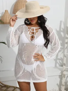 Detail of white crochet bikini cover-up with sexy lace-up deep V-neck and long sleeves.