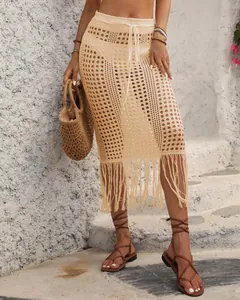 Detalle de una falda midi de ganchillo beige con dobladillo de flecos y cordón ajustable