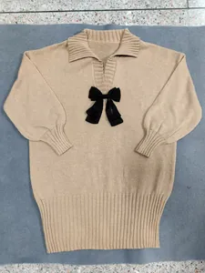 Detailed full view of a beige polo collar knitted dress featuring a black ribbon bow