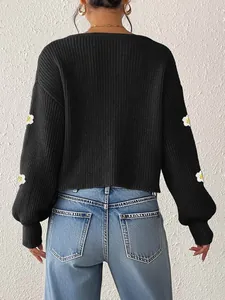 Rückansicht eines schicken schwarzen Strick-Cardigans mit 3D-Häkelblumen-Details