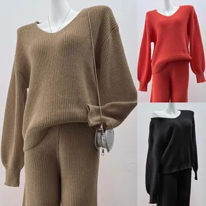 Detailed view of the V-neck knitted sweater and pants set in brown, red, and black.
