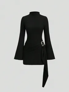 Detail view of black textured knit bodycon mini dress featuring a gold metal buckle
