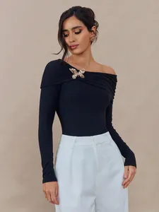 Haut élégant femme à manches longues noir à une épaule avec broche papillon dorée