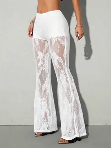 Dettaglio dei pantaloni a zampa in pizzo bianco con un design trasparente