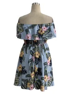 Close-up view of elegant floral off-the-shoulder dress with hibiscus print on mannequin.