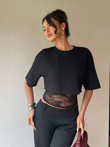 Detail view of women's black crop t-shirt featuring intricate waist lace splice design.