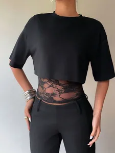 Detail view of women's black short sleeve crop top with elegant floral lace patchwork