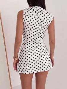 Back view of a white polka dot mini dress featuring elegant gold shoulder buckle detail
