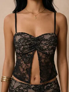 Detailopname van zwarte kanten camisole top met split aan de voorkant en fijne bandjes