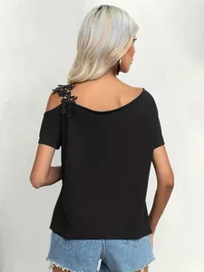 Rear view of black off-shoulder t-shirt with elegant floral lace applique details